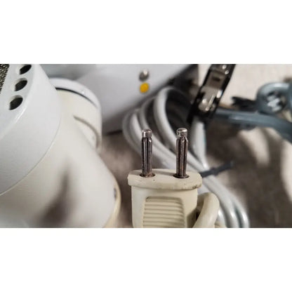 Beige plastic electrical plug with two metallic prongs on the back side of eppendorf centrifuge 5415 r for reuse medical use