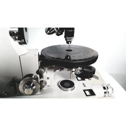 Black and silver compound microscope with rotating stage and lenses shown with eppendorf centriifuge 5415 R for reuse medical applications