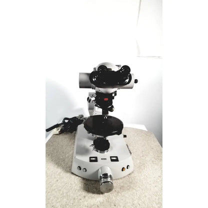 Eppendorf centriifuge 5415 r with white and black stereo microscope, dual eyepieces, rotating stage, and metallic knobs for reuse medical tasks