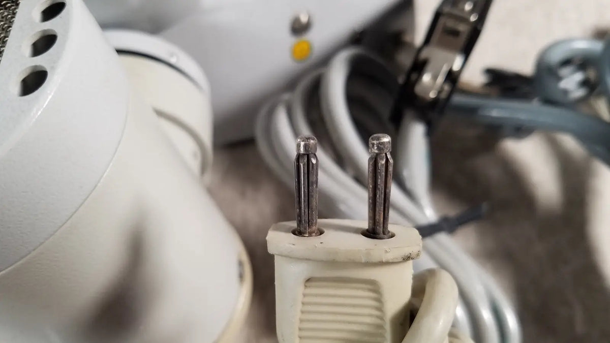 Beige plastic electrical plug with two metallic prongs on the back side of eppendorf centrifuge 5415 r for reuse medical use