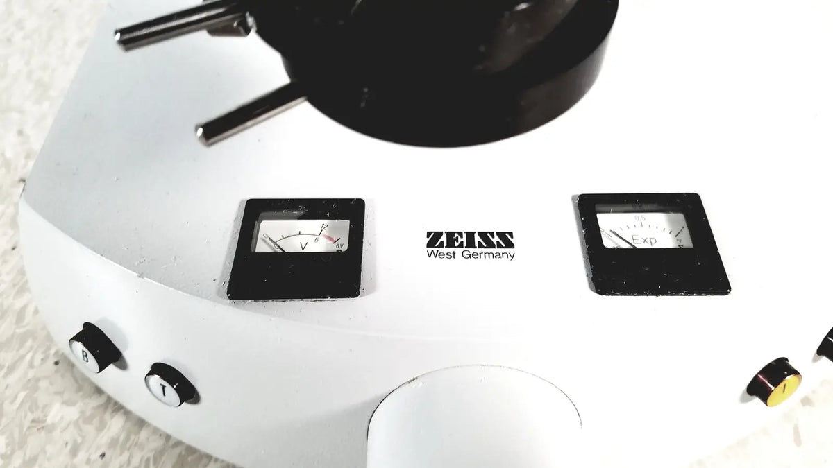 White zeiss microscope base with black dials and objective turret shown alongside eppendorf centriifuge 5415 r for reuse medical use