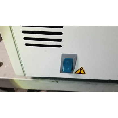 Blue toggle switch with gray housing on white appliance panel of eppendorf centriifuge model 5810 for reuse medical purpose