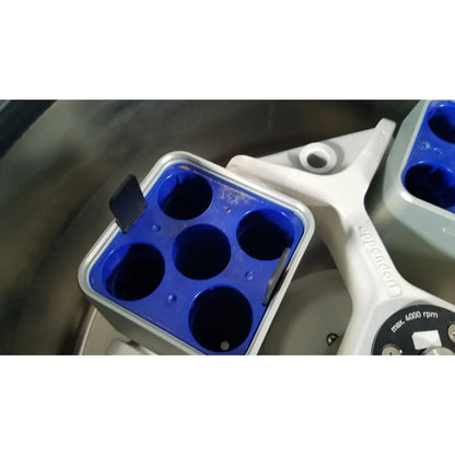 Blue plastic sample holder with six wells mounted on white eppendorf centriifuge model 5810 arm for reuse medical labs