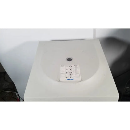 White plastic eppendorf centriifuge model 5810 with circular lid and control panel for laboratory use
