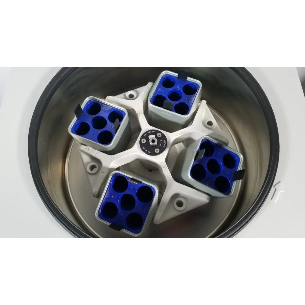 White and blue eppendorf centriifuge model 5810 rotor with four compartments holding sample tubes for reuse medical use