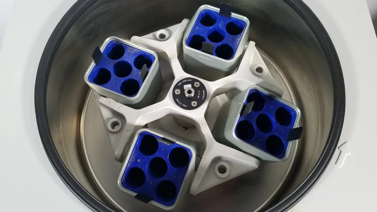 White and blue eppendorf centriifuge model 5810 rotor with four compartments holding sample tubes for reuse medical use