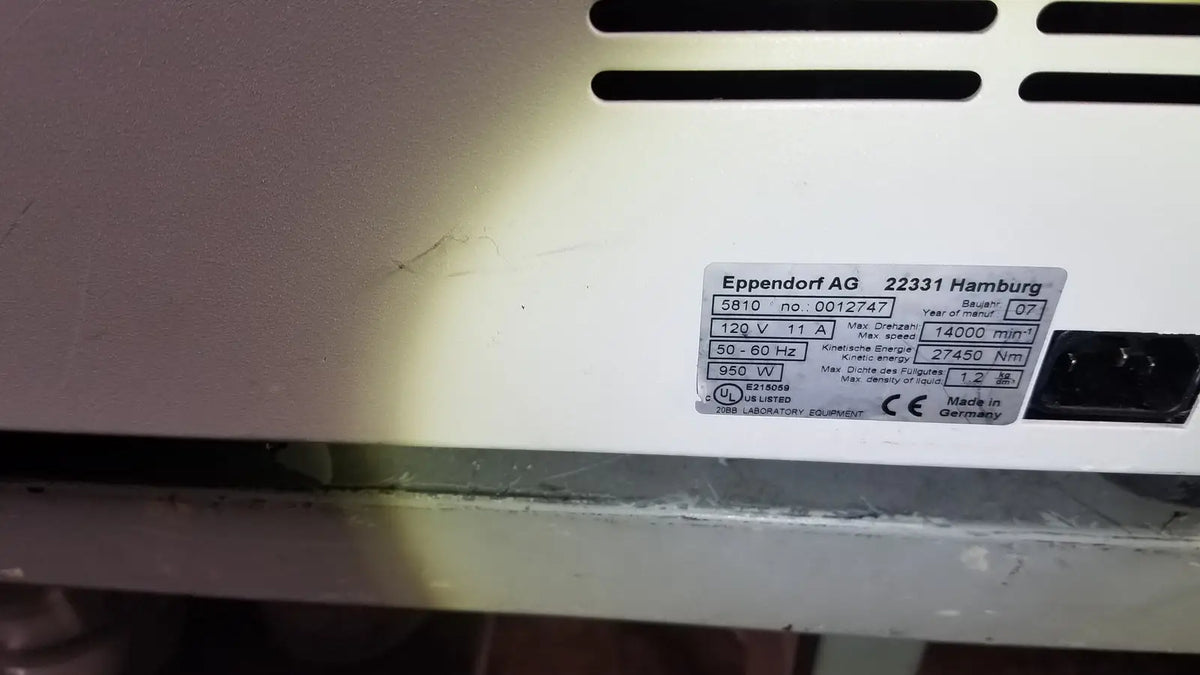 White plastic appliance label with black text on the back of eppendorf centriifuge model 5810 showing manufacturer and specs