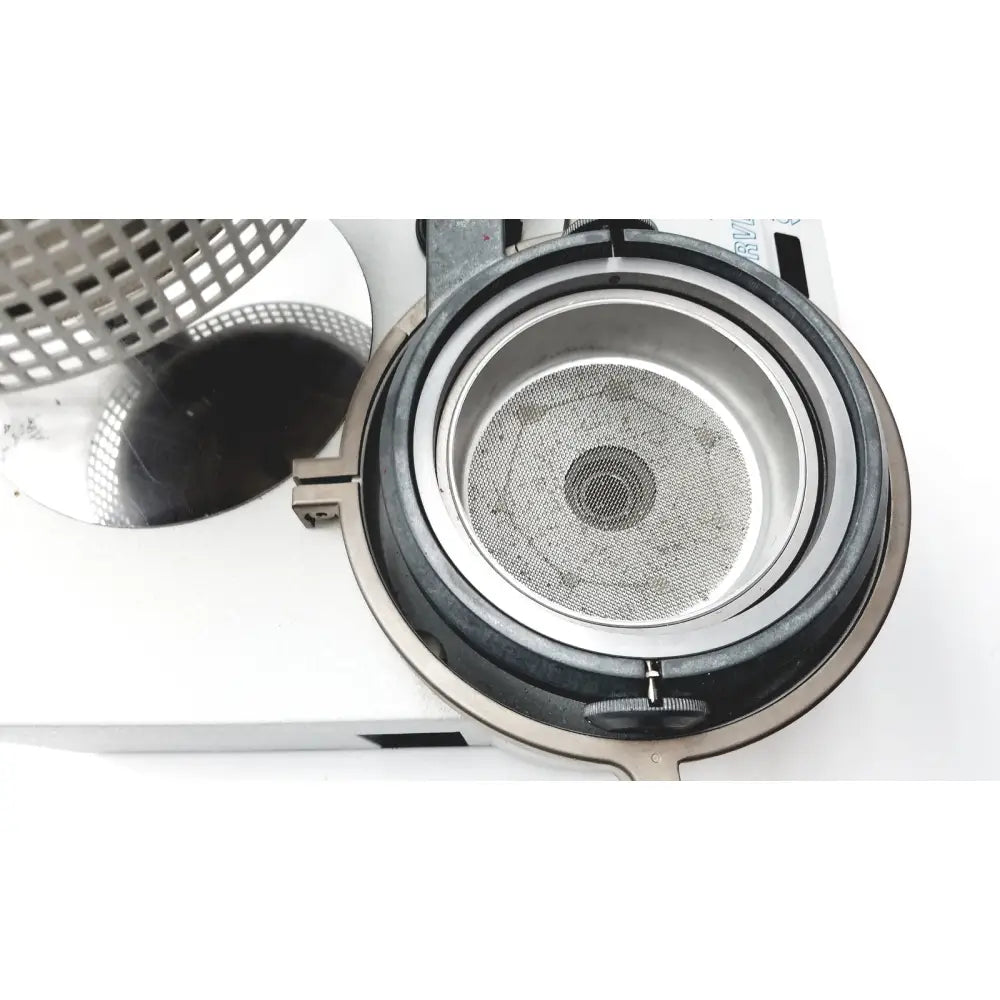 Silver-toned metal mesh strainer with black rubber seal and clasp for dental lab thermoforming in Erkodent Erkoform-RVE system