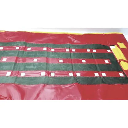 Evacusled emergency patient evacuation sled featuring a red and green striped fabric roll-up mat with white square accents