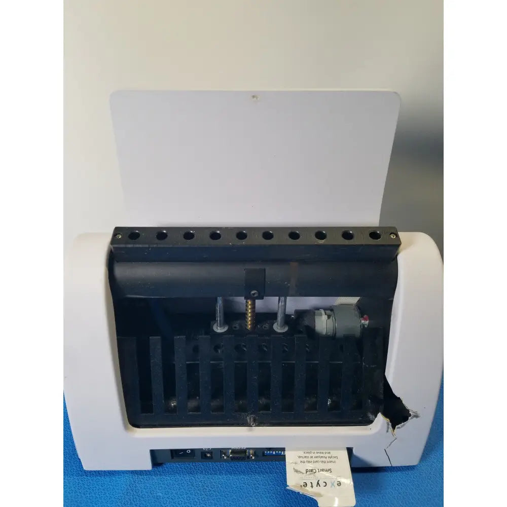 White and black excyte m automated esr analyzer with digital display and damaged side panel visible on the back side