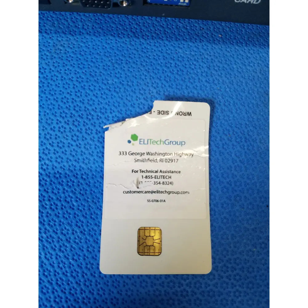 A white elitechgroup sim card with gold contact pad on blue surface for excyte m automated esr analyzer