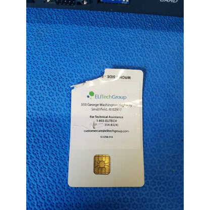 A white elitechgroup sim card with gold contact pad on blue surface for excyte m automated esr analyzer