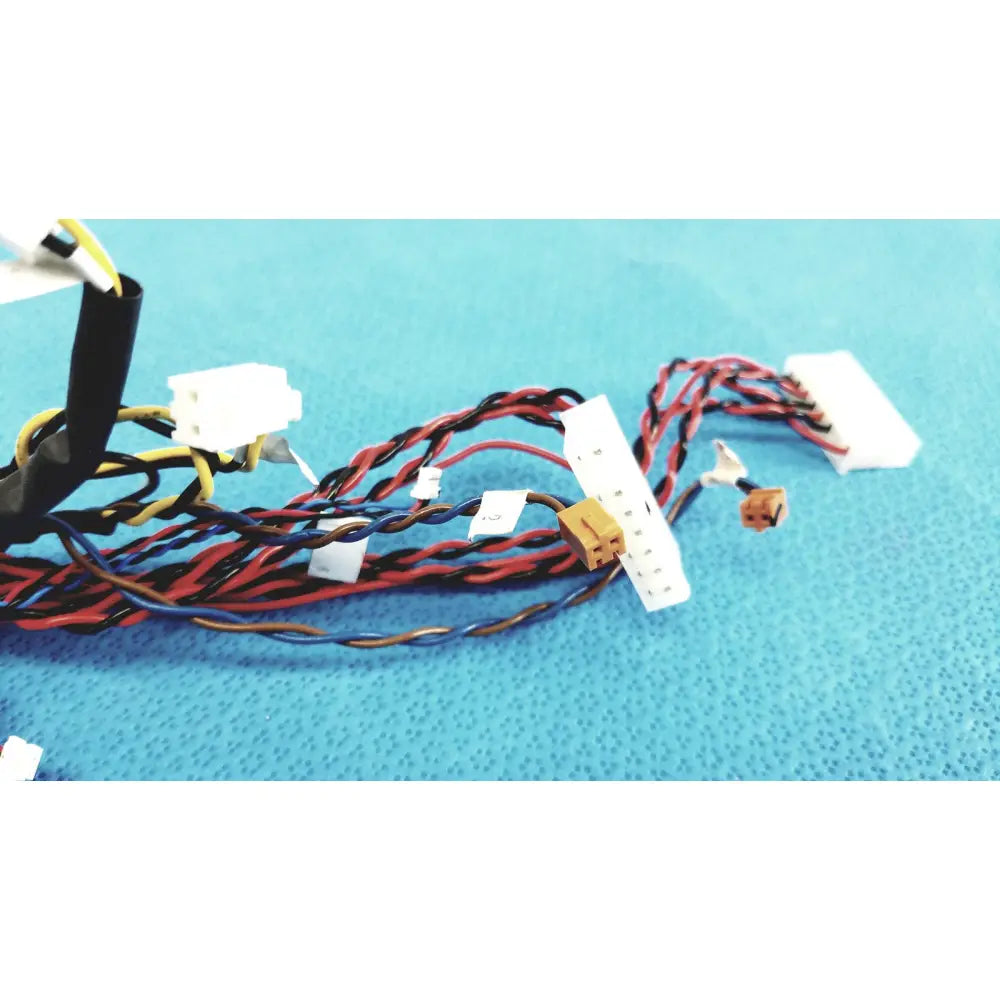 A tangle of female multi-pin connectors wire harness cables with multicolored wires and white and beige plastic plugs
