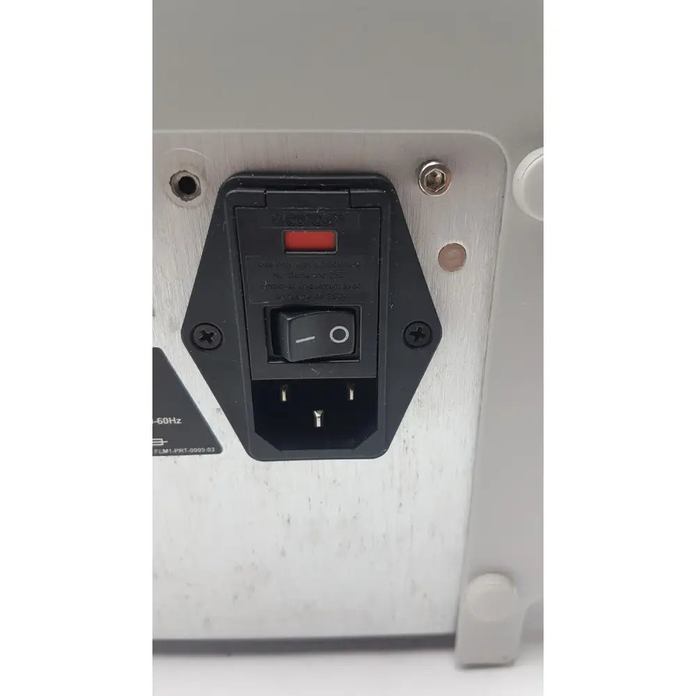 Black power input panel with red indicator light and toggle switch on brushed silver metal chassis of filmarray instrument fa3112 pcr