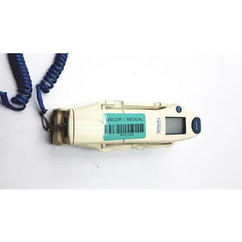 Cream-colored plastic firsttemp genius calibrator with digital display, blue coiled cord, and metal clasp for calibration