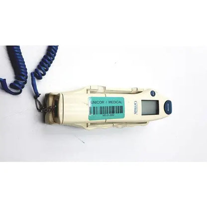 Cream-colored plastic firsttemp genius calibrator with digital display, blue coiled cord, and metal clasp for calibration