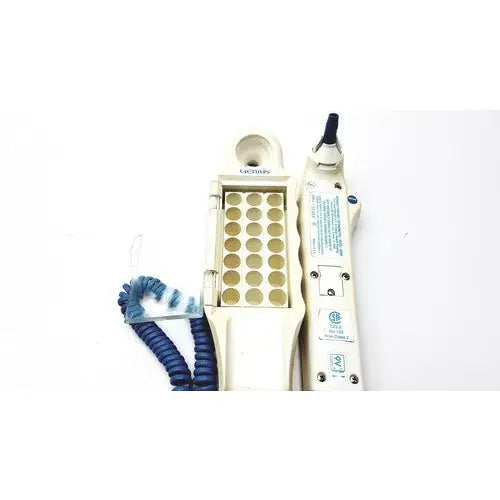 Cream-colored plastic firsttemp genius calibrator dental handpiece with blue coiled cord and gold circular ports