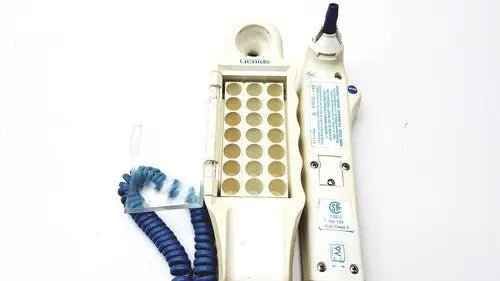 Cream-colored plastic firsttemp genius calibrator dental handpiece with blue coiled cord and gold circular ports
