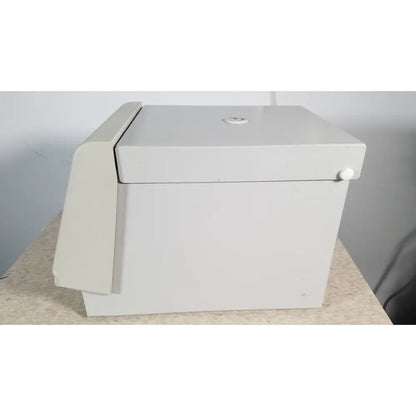 A sleek off-white metal safe with hinged lid and circular keyhole on top in the fisher scientific marathon 16km benchtop model