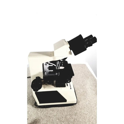 Beige and black compound microscope with dual eyepieces and specimen stage fisher scientific micromaster 12-561-3faz