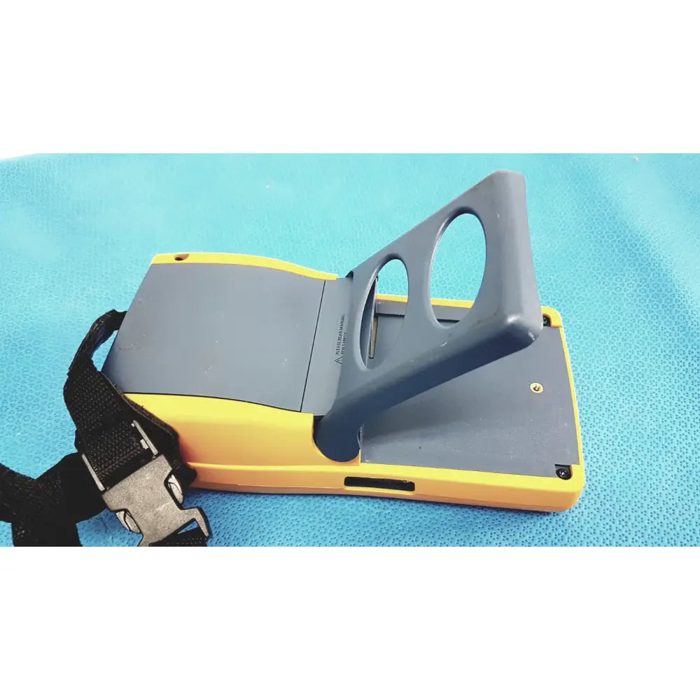 Yellow and gray Fluke DTX-1800 handheld cable analyzer with hinged cover revealing internal compartment for network cable certifier use