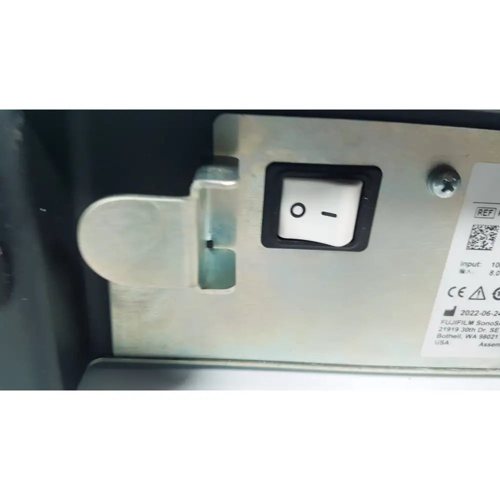 Silver metal power switch with black border and white toggle on metallic panel of fuji film sonosite power pack dock