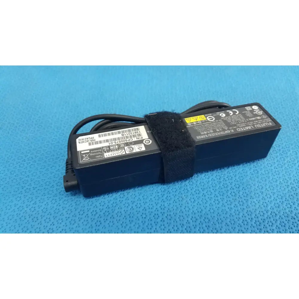 Black fujitsu ac adapter power supply 19v 3.16a with coiled cable secured by black velcro strap for laptop use