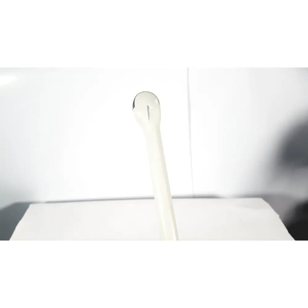 White plastic spoon with smooth rounded handle shown alongside fukuda denshi ultrasound probe trans vaginal device