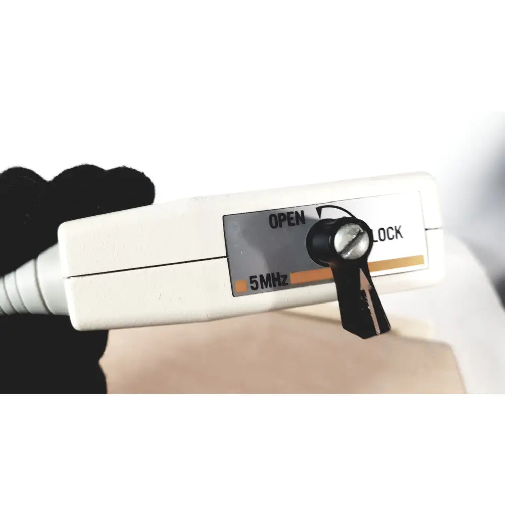 White plastic fukuda denshi ultrasound probe trans vaginal 5mhz with black toggle switch held in gloved hand