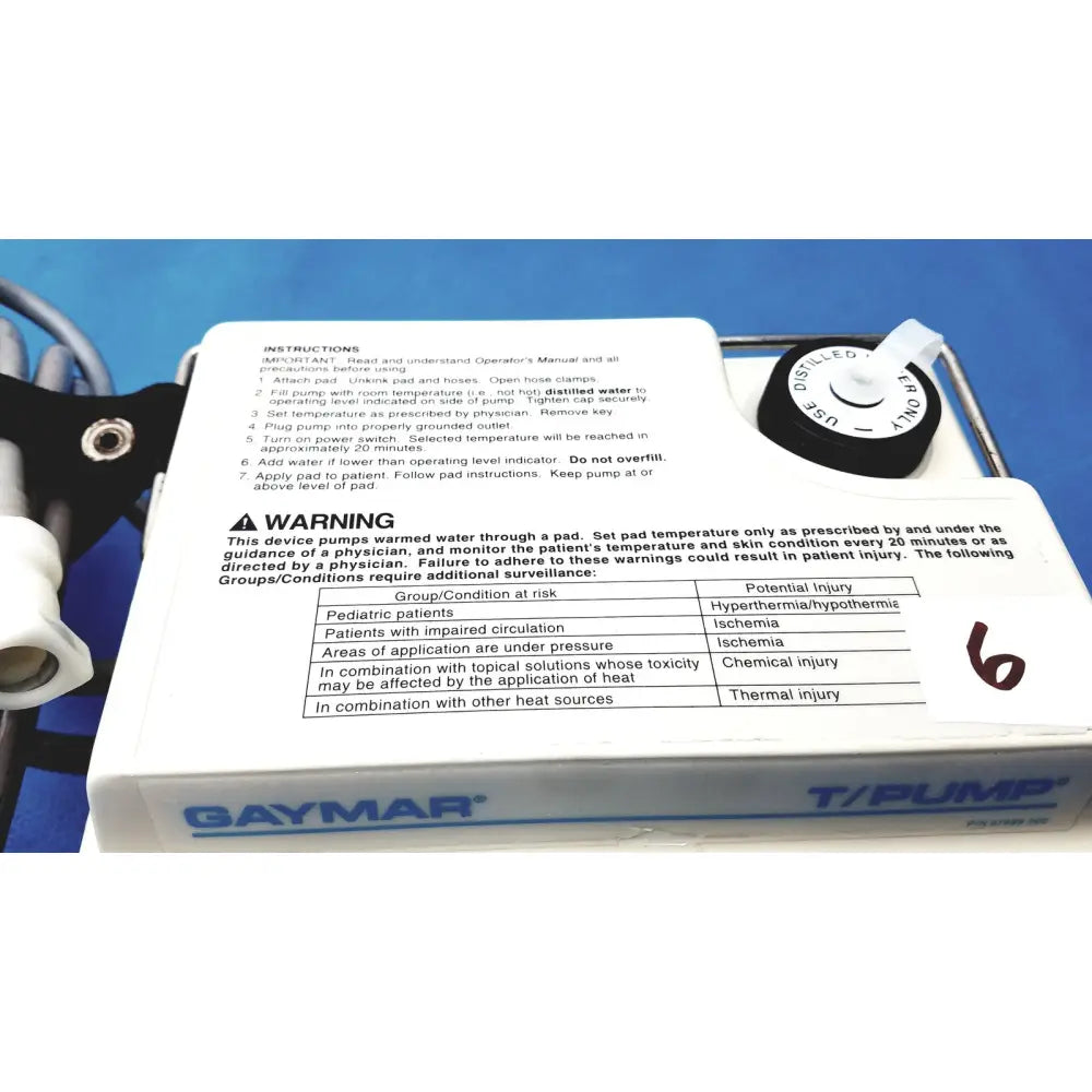 White plastic gaymar t pump tp500c heat therapy pump with black control dial and printed instructions for medical use