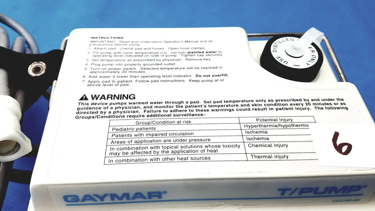 White plastic gaymar t pump tp500c heat therapy pump with black control dial and printed instructions for medical use