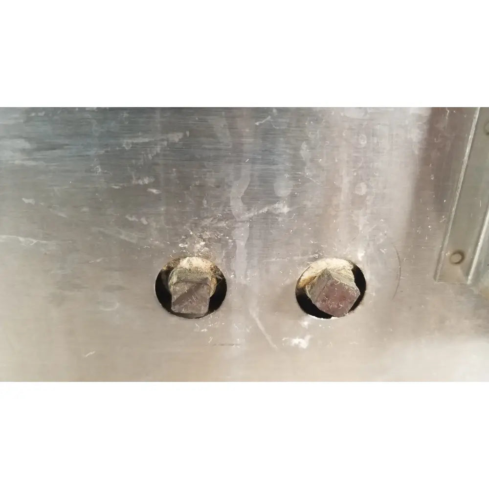 Two hexagonal bolts with a dark finish on a brushed stainless steel panel of gca precision scientific dubnoff metabolic incubator