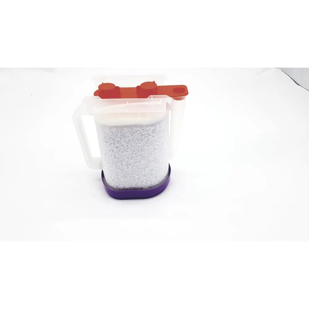 Clear plastic measuring cup with white handle orange lid filled with gray granules calcium hydroxide exp amsorb plus