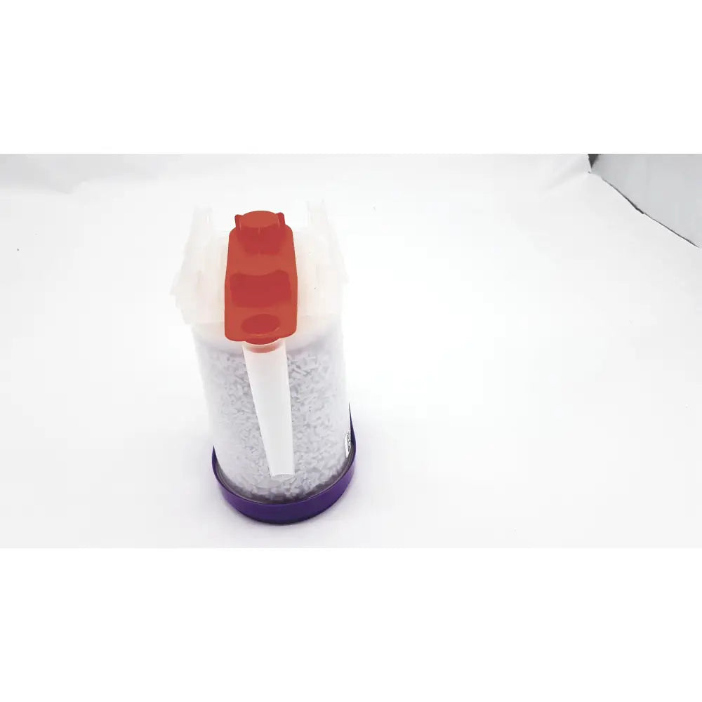 A transparent plastic container with red and white pump dispenser filled with gray granules of ge amsorb plus calcium hydroxide exp 2026-11