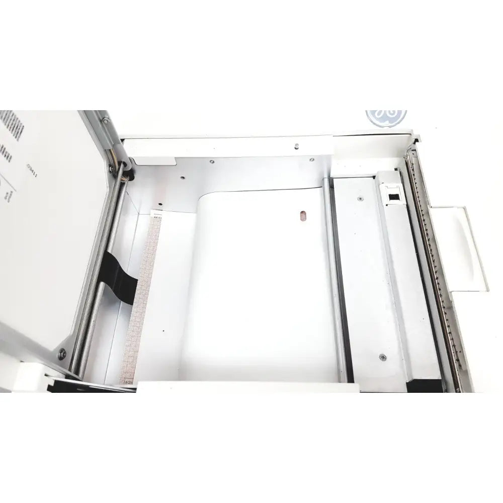 Interior view of white GE case stress test exercise testing unit showing metallic frame and paper tray components