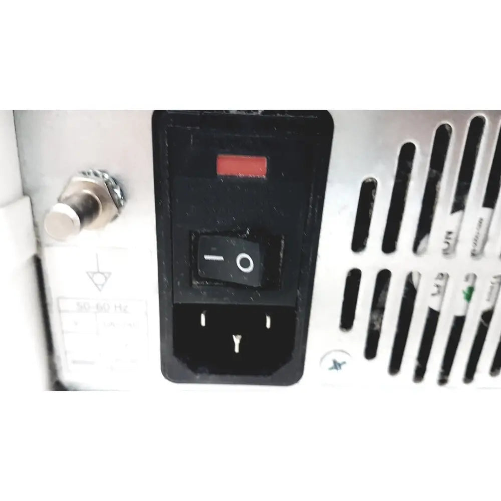 Black power switch with red indicator light and grounding symbol on white appliance of ge cic pro mp100d central station