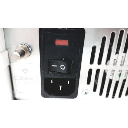 Black power switch with red indicator light and grounding symbol on white appliance of ge cic pro mp100d central station
