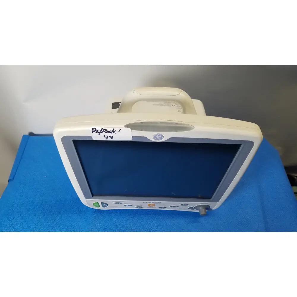 White ge dash 5000 patient monitor ecg with handle and control buttons along the bottom edge for critical care use
