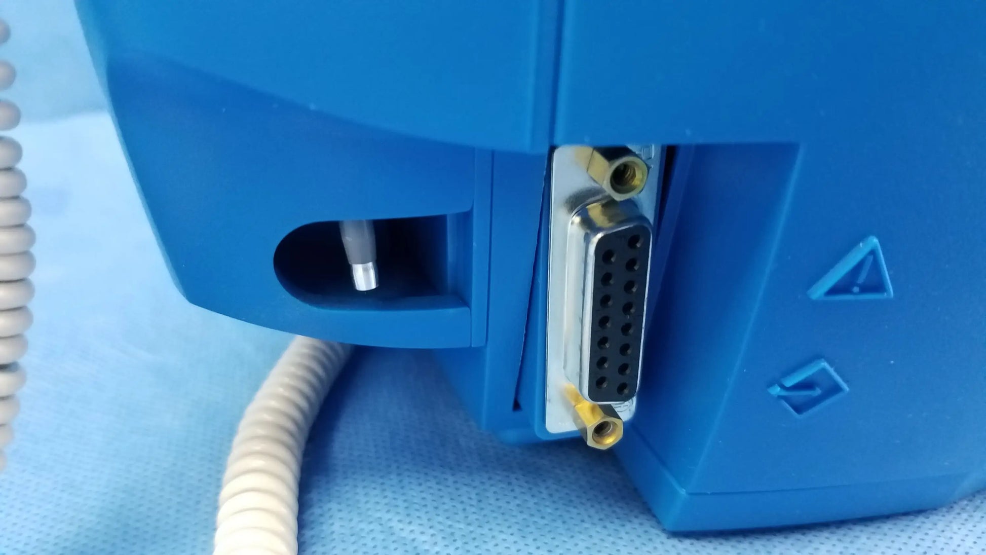 Blue ge dinamap v100 vital signs monitor back with silver d-sub connector and yellow locking screws for nibp cuffs and power adapter