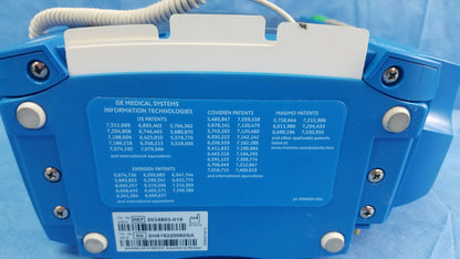 Blue ge dinamap v100 vital signs monitor back with white label showing patent info barcode nibp cuffs and power adapter