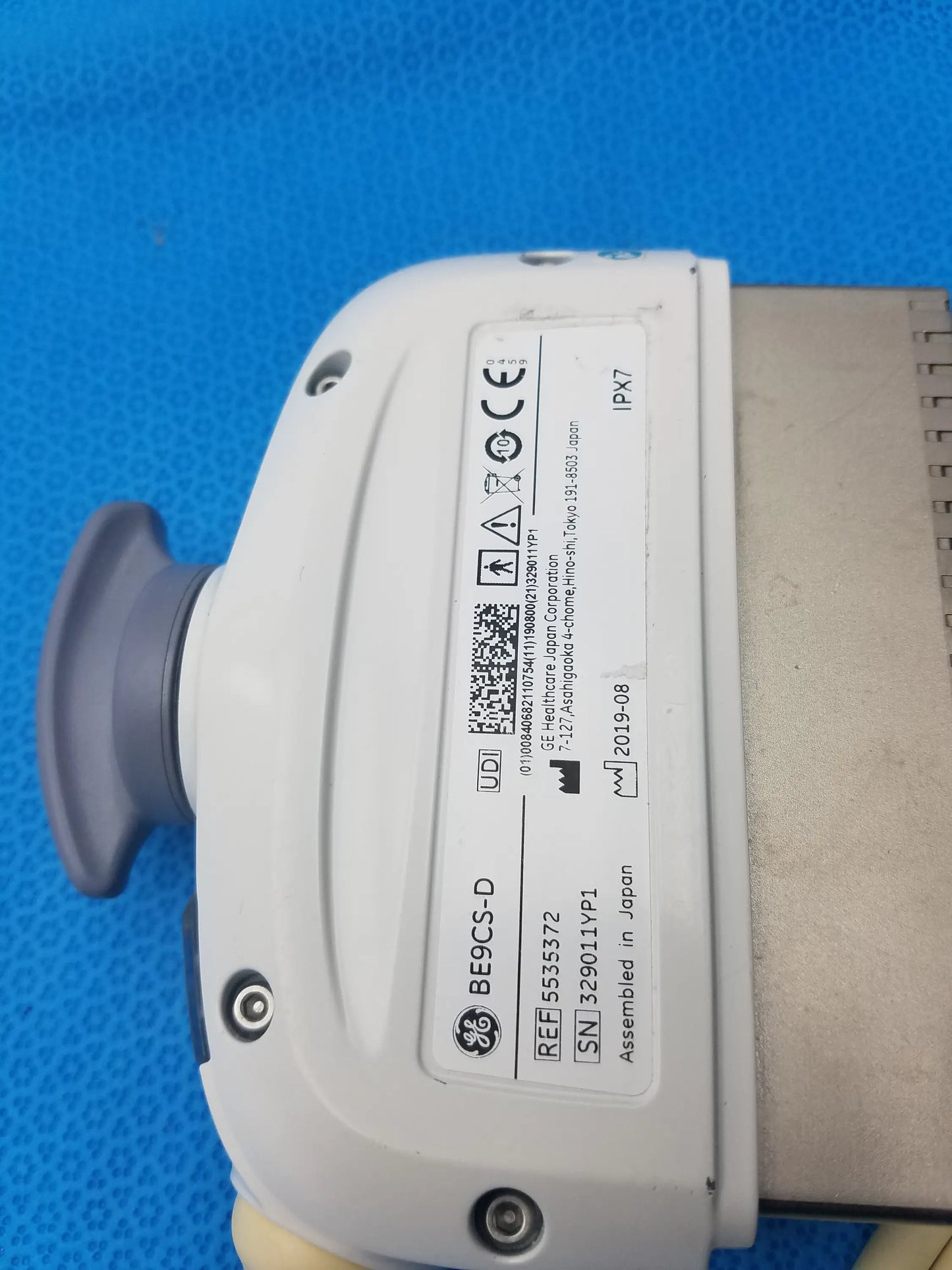 White ge healthcare be9cs-d bi-plane micro convex ultrasound probe with gray handle and labeled specifications on its side