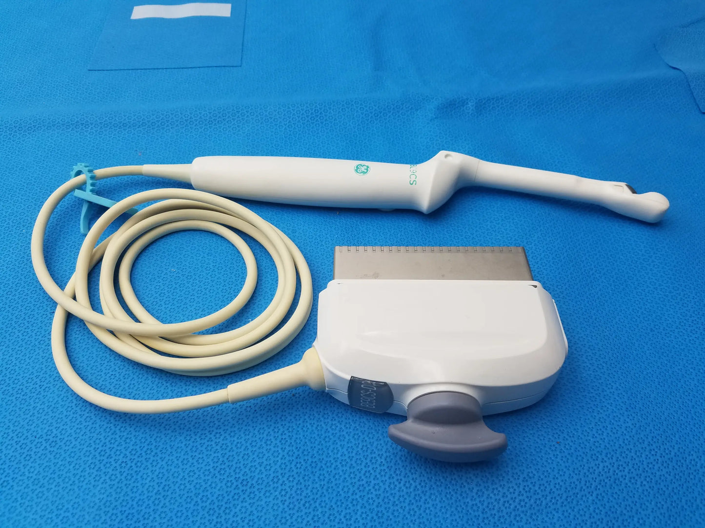 White ge sonosite bi-plane micro convex ultrasound transducer with beige cable and gray control knob side view