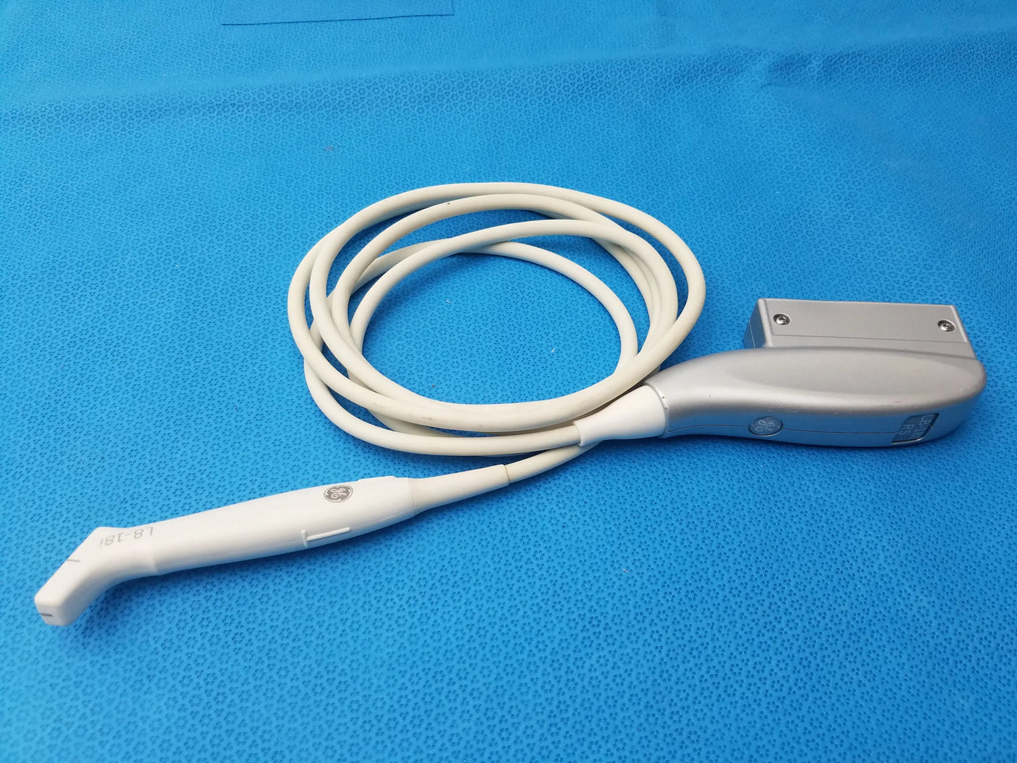 White and silver ge healthcare l8-18i-rs ultrasound transducer probe with coiled cable and ergonomic design