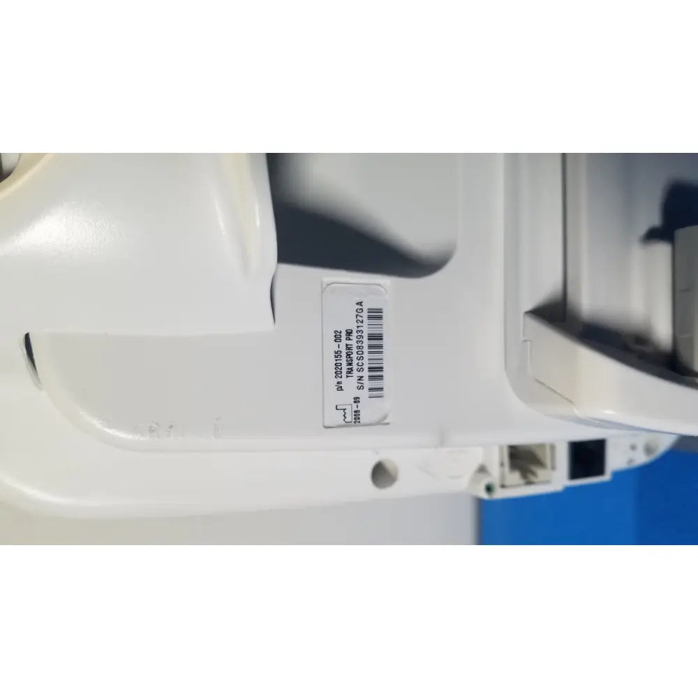 White plastic security camera with barcode label and serial number on the back of ge healthcare transport pro patient monitor