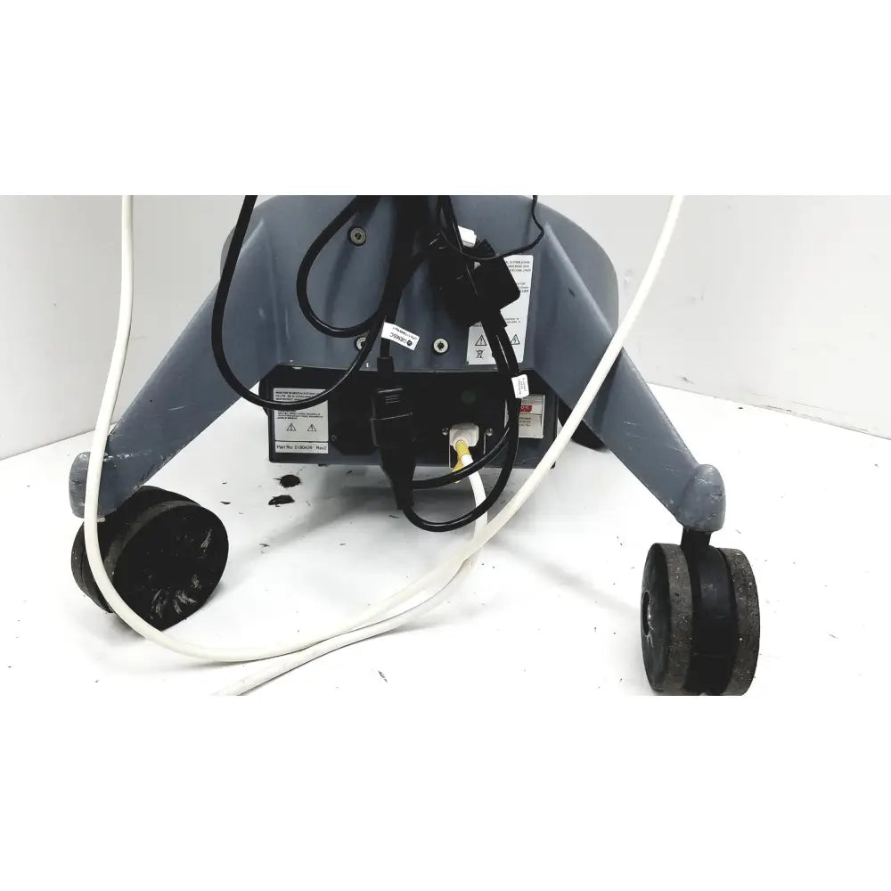 Gray industrial-grade floor cleaning machine with black wheels and cords shown with logiq e portable ultrasound machine untested