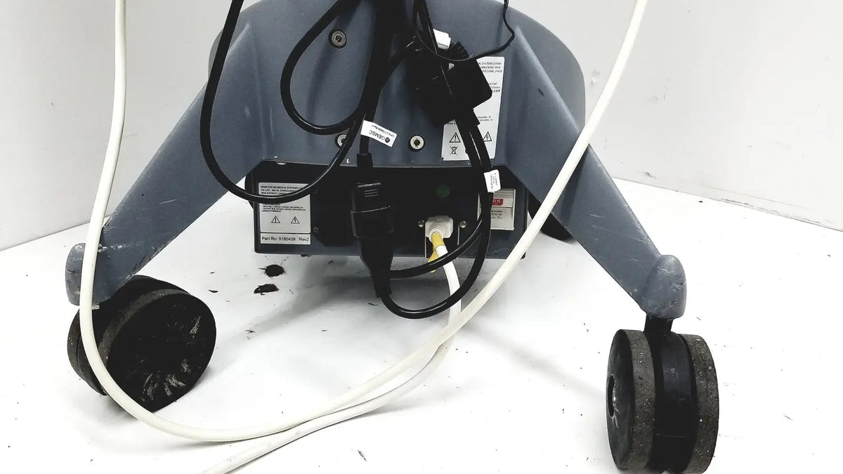 Gray industrial-grade floor cleaning machine with black wheels and cords shown with logiq e portable ultrasound machine untested