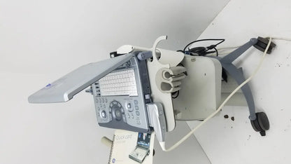 Gray and white GE LOGIQ E portable ultrasound machine with built-in keyboard and monitor on wheeled cart untested portable ultrasound