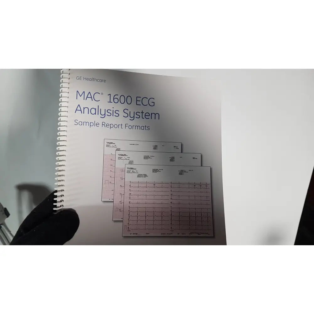 White spiral-bound manual with pink grid-lined pages for medical mac1600 ecg analysis system sample reports