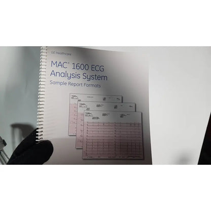 White spiral-bound manual with pink grid-lined pages for medical mac1600 ecg analysis system sample reports