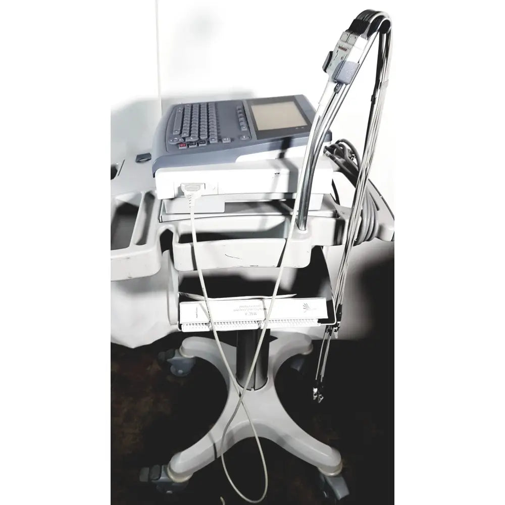 Medical mac1600 ecg analysis system with gray control panel white trays and metallic cables on cart stand